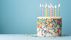 a birthday cake with white frosting and colorful sprinkles