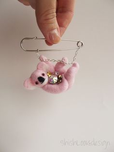 a hand holding a pink bear key chain