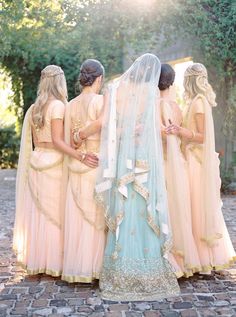 a group of women standing next to each other wearing dresses and veils on their heads