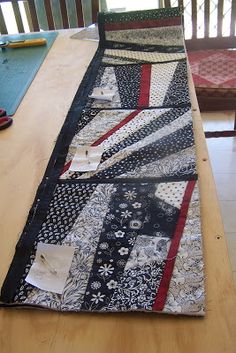 the table is covered with many different quilts