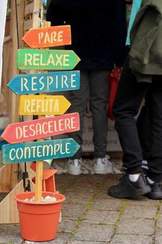 there are many signs on the pole that say relaxe, respire, recepta, descalore, contemple and pare