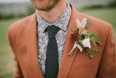 a man wearing a suit and tie with flowers on his lapel