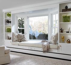 a living room filled with white furniture and lots of windows