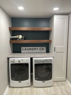 a washer and dryer in a laundry room with built - in shelving