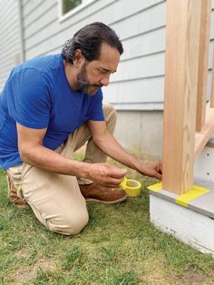 a man in blue shirt and khaki pants working on siding