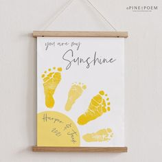 a hand and foot print hangs on the wall next to a sign that says, you are my sunshine