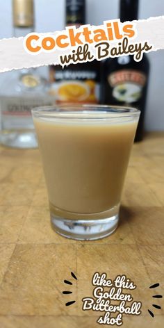 a glass filled with liquid sitting on top of a wooden table