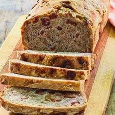 sliced loaf of fruit bread sitting on top of a cutting board