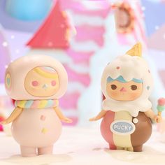 two toy figurines sitting next to each other in front of a colorful background