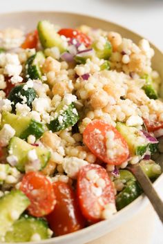 a salad with cucumbers, tomatoes, and feta cheese in a bowl