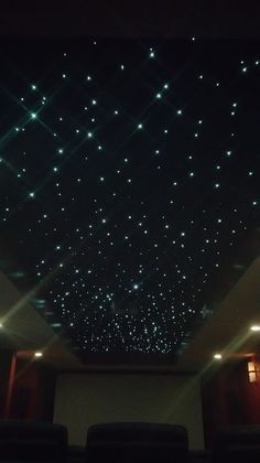 the ceiling is covered with stars and lights in a dark, dimly lit room at night