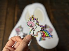 a person holding up a sticker with a unicorn on it