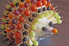 a hedgehog made out of grapes and cheese on a table with toothpicks