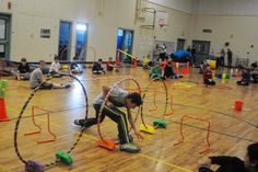 several children are playing with obstacles in an indoor gym