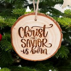 a wooden ornament hanging on a christmas tree with the words, christ the savor is born