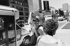 a woman sitting on the curb talking on her cell phone with a man standing next to her