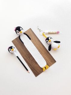 the penguins are made out of crochet and have pencils in their hands