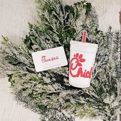 two cold drinks sitting next to each other on top of snow covered ground with trees in the background