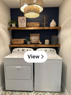 a washer and dryer in a small room with shelves above them that have pictures on the wall