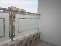 a bathroom with tiled floors and glass walls