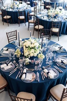 the table is set with blue linens and white flowers