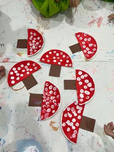 children are making red and white hearts out of paper plates on a table with paint