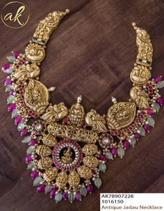 an elaborate necklace with red and green stones