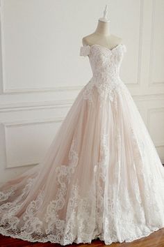 a wedding dress is displayed on a mannequin in front of a white wall