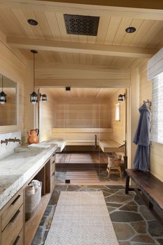 a bathroom with stone flooring and wooden walls