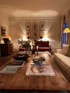 a living room filled with furniture and a wooden table topped with books on top of it