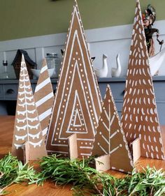 some brown and white paper trees on a wooden table in front of a kitchen counter