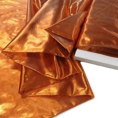 two sheets of shiny gold foil on top of each other, one folded and the other unwrapped