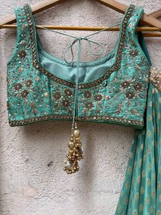 A three-piece jade green zari lehenga set from the Priti Sahni collection. This beautiful georgette small butti green lehenga with a heavy border of sequin, pearl and zari work detail with green accent is paired with a raw silk green blouse with sequin and zardosi embroidery detail all over. The lehenga has side hanging ball tassels to the waistline. And the blouse has a sequins tassel tie-up at the back. This outfit is completed with a sequin tulle dupatta with jade green accent in net material Green Embellished Pre-draped Saree For Wedding, Elegant Green Dola Silk Choli, Transitional Green Dola Silk Choli, Designer Green Dola Silk Choli, Green Choli With Zari Work For Transitional Season, Embellished Green Lehenga For Festive Occasions, Festive Green Embellished Lehenga, Festive Embellished Green Lehenga, Green Dola Silk Choli For Reception