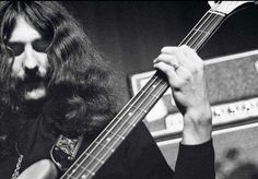 a man with long hair playing a bass