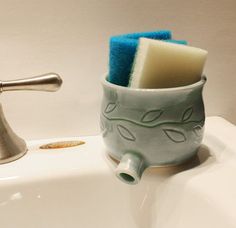 a toothbrush holder sitting on top of a sink next to a faucet