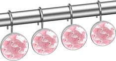 four pink flamingos are hanging from a metal rod with three round knobs on each side