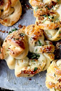 some bread rolls with cheese and herbs sprinkled on them