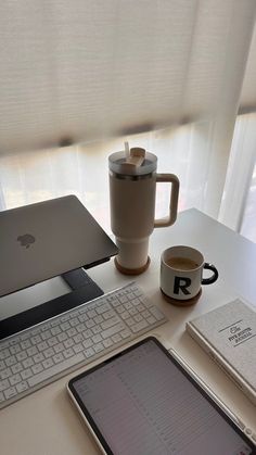 an apple laptop computer sitting on top of a desk next to a cup of coffee