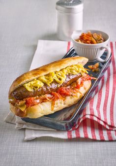 a hot dog sitting on top of a bun next to a bowl of coleslaw