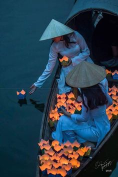 two people in a boat filled with paper lanterns