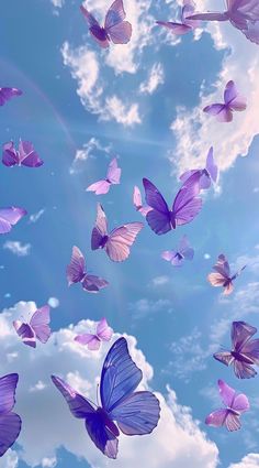 many purple butterflies flying in the air with clouds behind them and blue sky above it