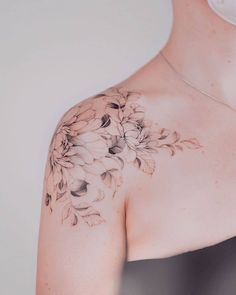 a woman's shoulder with flowers on it, and the back of her body