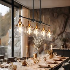 a dining room table with many lights hanging from it's sides and place settings on the table