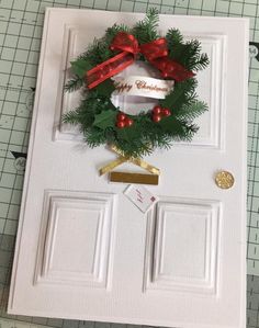 a white door with a christmas wreath and ribbon hanging on it's front door