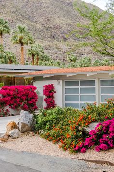 a house with flowers and rocks in front of it