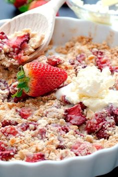 a dish with strawberries and crumbled toppings in it on a table