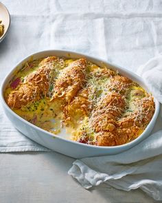 a casserole dish with meat and cheese in it on a white table cloth