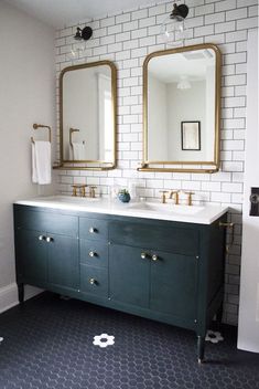 a bathroom vanity with two mirrors above it and a white brick wall behind the sink