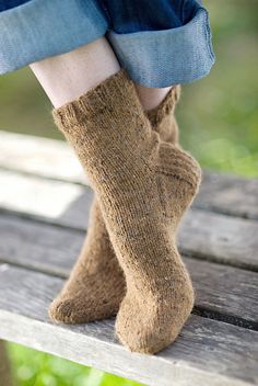 a woman's legs with socks on sitting on a bench