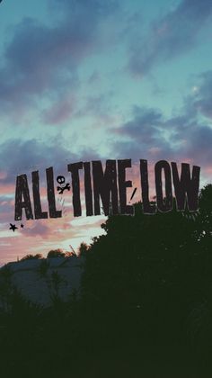 the words all time low are displayed in front of a sunset